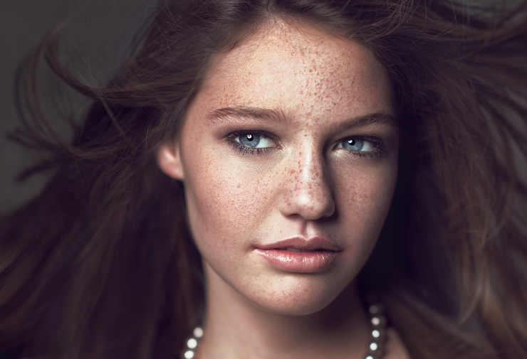 Woman with freckles in the studio